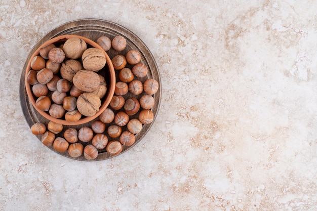 A wooden bowl of macadamia nuts and walnuts.