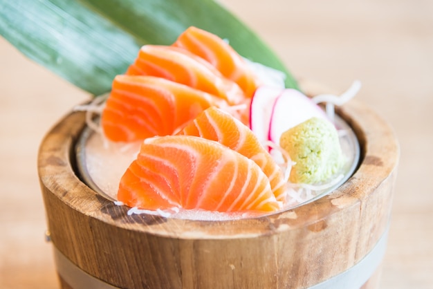 Free photo wooden bowl with fresh salmon fillets