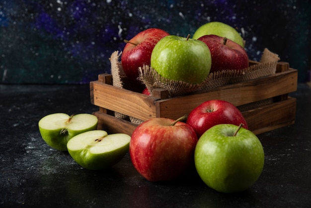 Free Photo wooden box of fresh organic apples on black surface. .