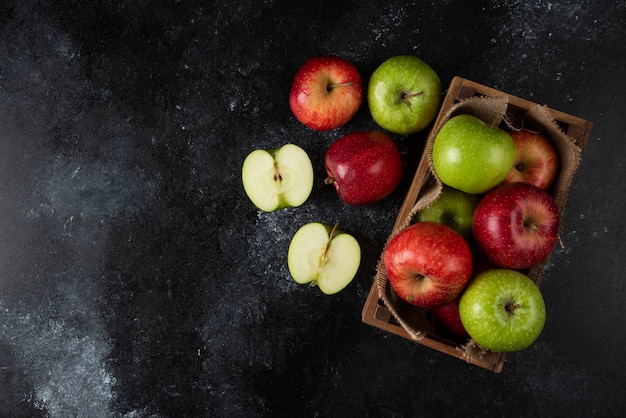 Free photo wooden box of fresh organic apples on black surface. .