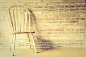 Free photo wooden chair with a brick wall background