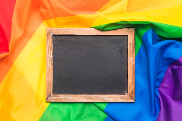 Free Photo wooden chalkboard and crumpled lgbt flag