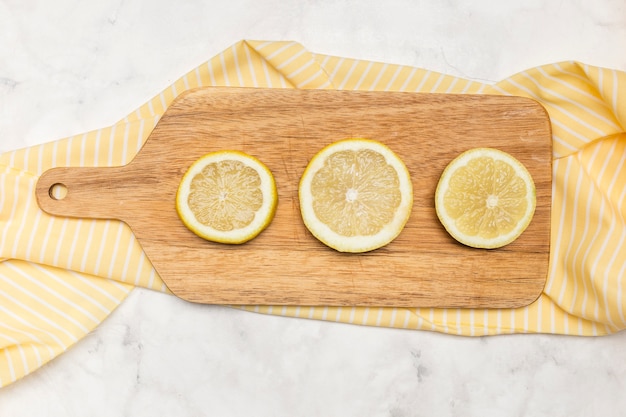 Free photo wooden chopping board with sliced lemons