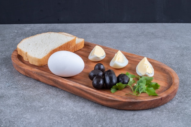 Free photo a wooden cutting board with boiled egg and slices of bread. high quality photo