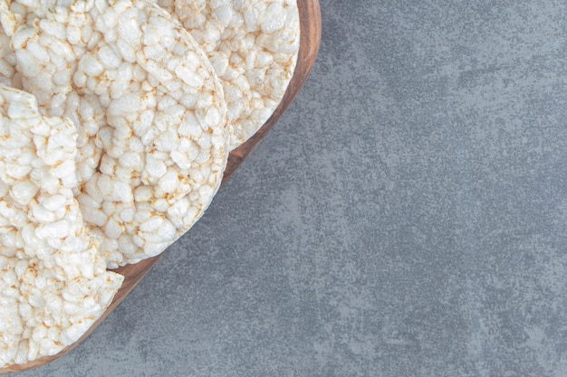 A wooden cutting board with puffed rice bread.