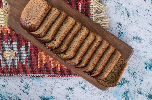 A wooden cutting board with slices of bread.