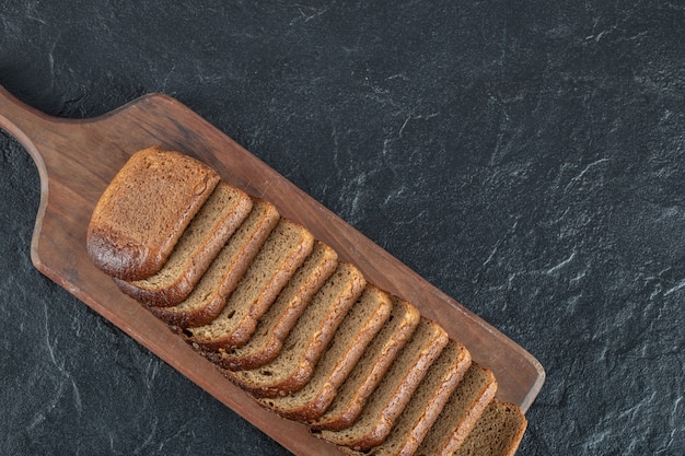 A wooden cutting board with slices of bread.