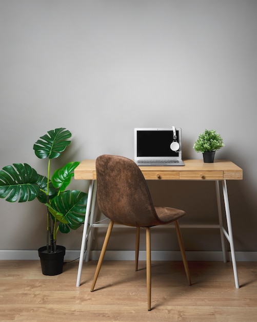 Wooden desk with chair and grey laptop