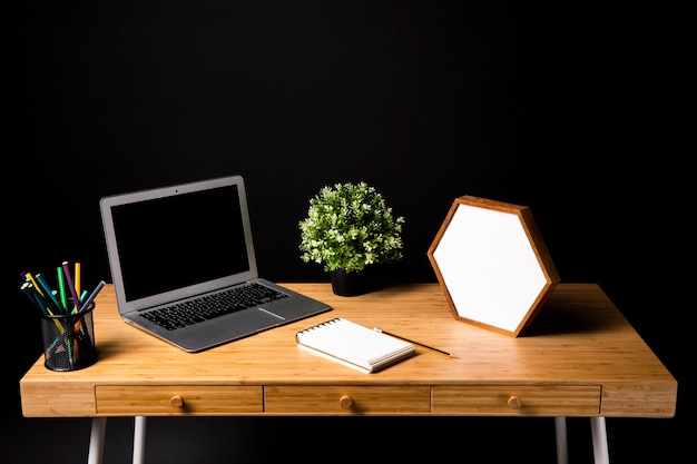 Wooden desk with laptop and notebook