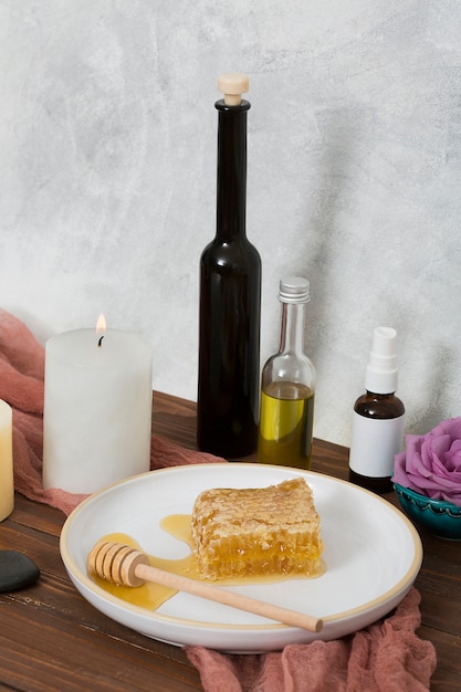 Free photo wooden dipper and ceramic white plate with essential oil bottle on wooden table