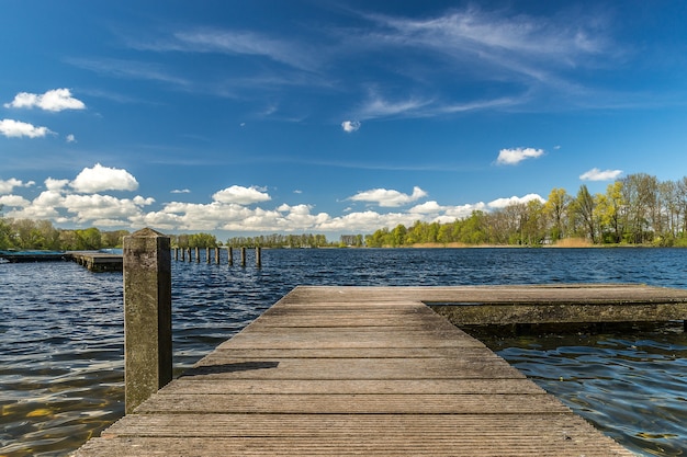 Free Photo wooden dock on the sea under the sunlight and a blue cloudy sky