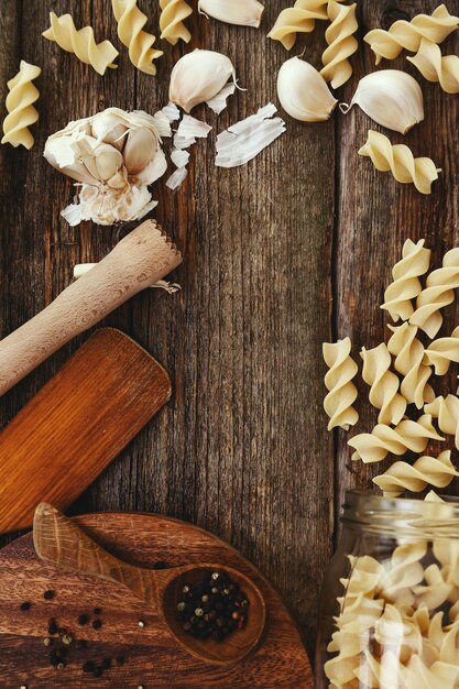 Wooden equipment on kitchen counter with spices and pasta