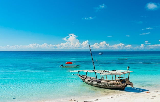 Wooden fishing ship on the white sand beach on low tide, Indian ocean. Zanzibar, Tanzania