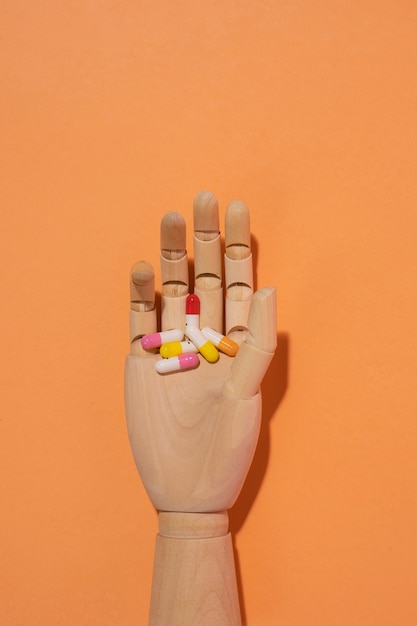 Wooden hand with pills