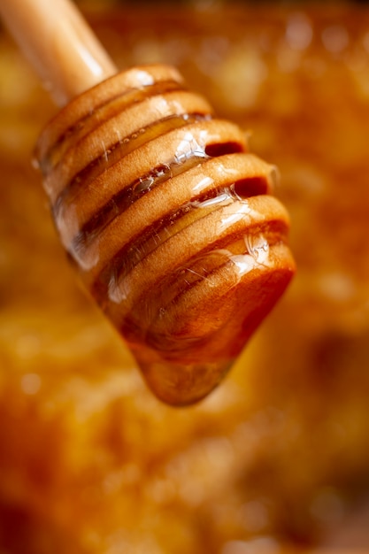 Wooden honey dipper with dripping honey