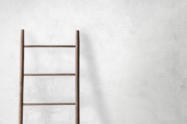 Free photo wooden ladder leaning against a concrete wall