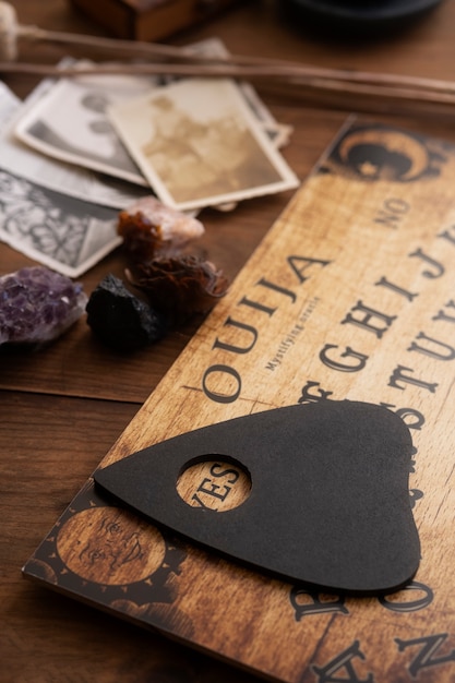 Free Photo wooden ouija board and old photos high angle