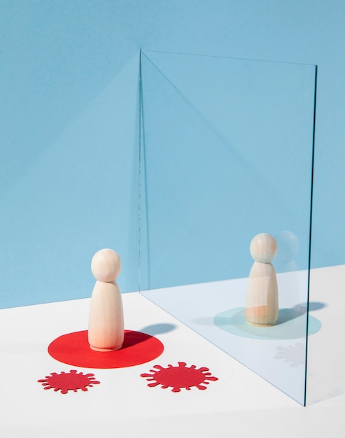 Free Photo wooden pawns with glass divider for safety against coronavirus