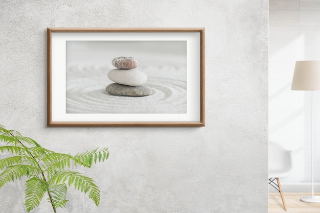 Free Photo wooden picture frame with zen stones photo on the wall interior concept