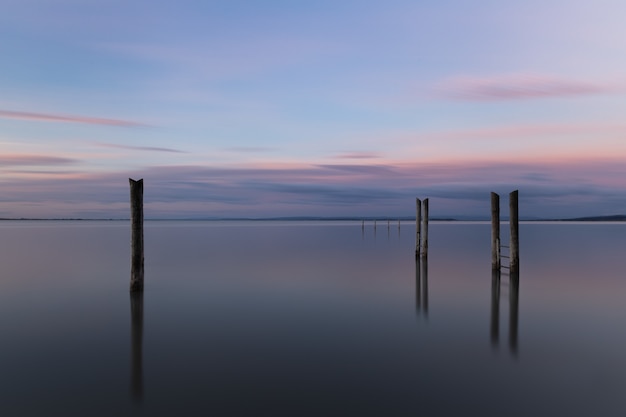 Free Photo wooden pier reflecting on the sea under the beautiful sunset sky