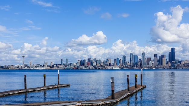 Free Photo wooden pier over a sea with the city of seattle, usa under the beautiful clouds