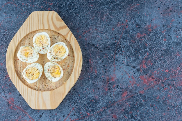 Free Photo a wooden plate with spices hard boiled eggs . 