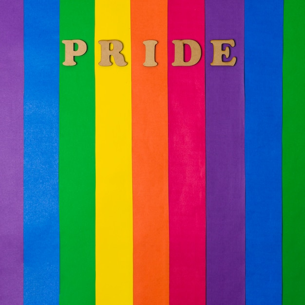 Free photo wooden pride word and bright lgbt flag