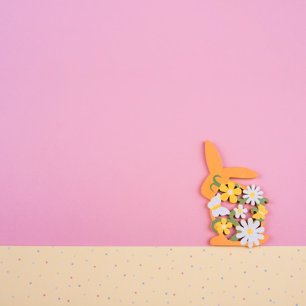 Free photo wooden rabbit with flowers on table