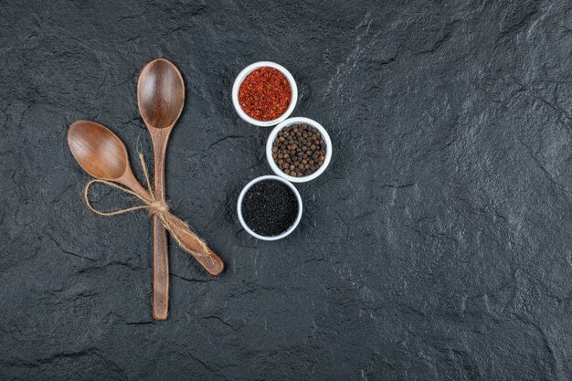 Wooden spoons with spices on a dark background. 