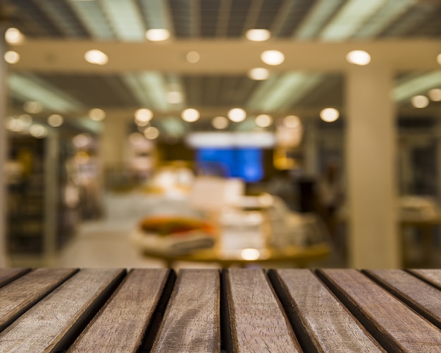 Free Photo wooden surface looking out to blurred shop