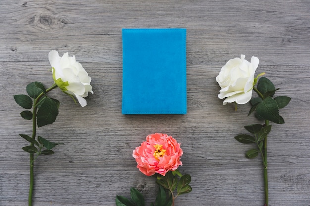 Wooden surface with book and pretty flowers