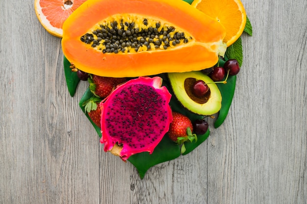 Wooden surface with dragon fruit, papaya and other fruits