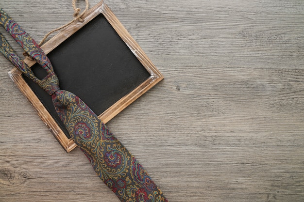 Free photo wooden surface with slate and necktie for father's day