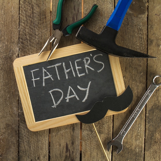 Free photo wooden surface with slate and tools for father's day