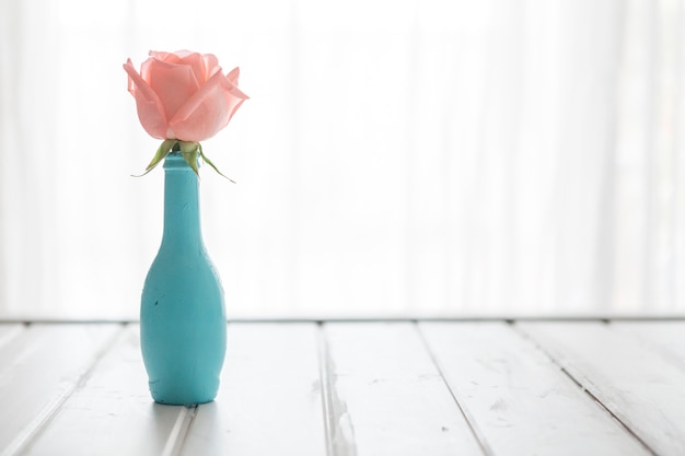 Wooden table with blue vase and flower