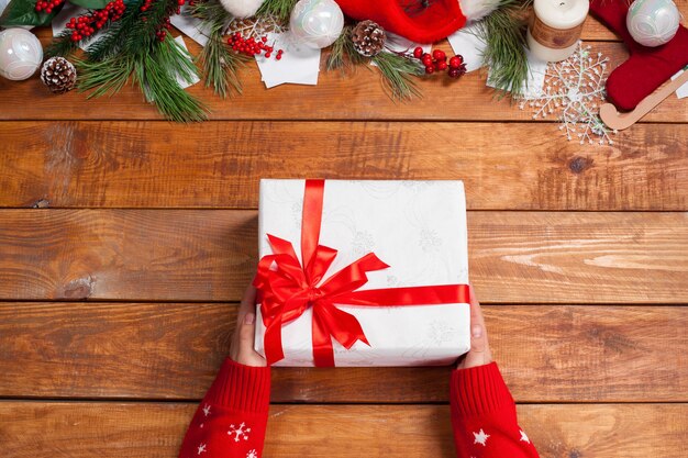 The wooden table with Christmas decorations and gift box