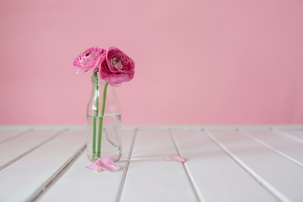 Wooden table with cute flowers and vase