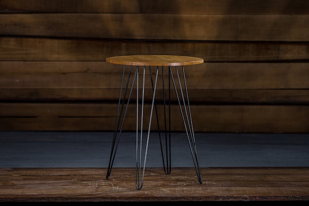 Wooden table with metal legs with a wooden wall