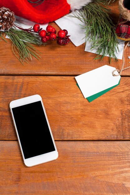 wooden table with a phone and Christmas decorations.