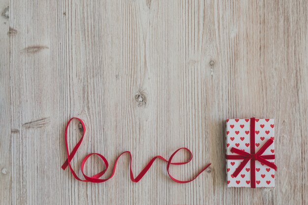 Wooden table with the word "love" and a gift box