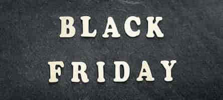 Free photo wooden text black friday on black textured background top view