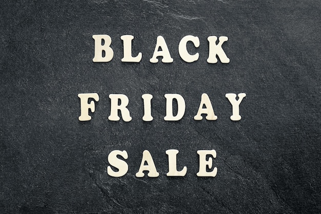 Free photo wooden text black friday sale on black textured background top view