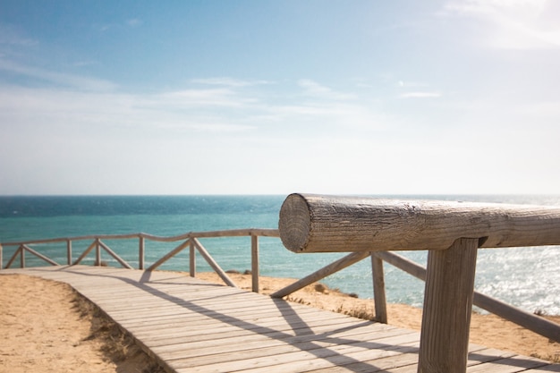 Free Photo wooden walkway with handrails along the beach at daytime