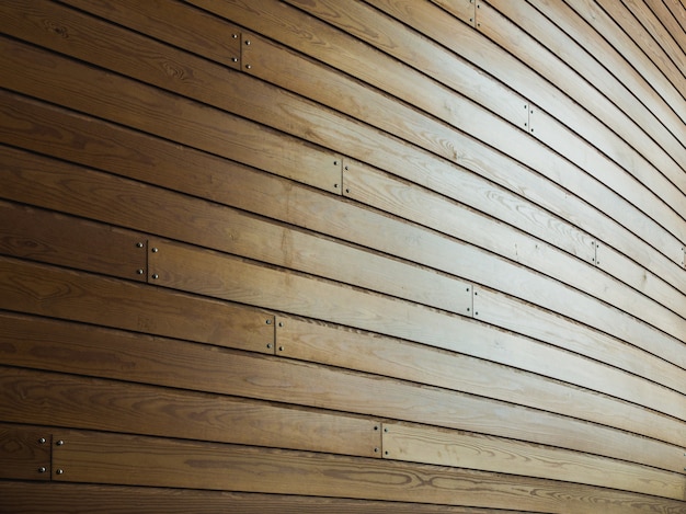 Wooden wall with nails in it under sunlight