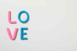 Free photo the word love is made of colored plasticine on a white background