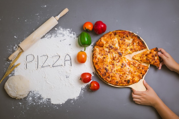 Word pizza written on flour with a tasty pizza