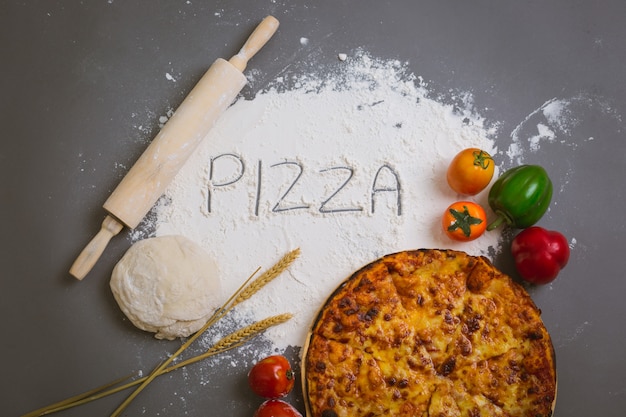 Free photo word pizza written on flour with a tasty pizza