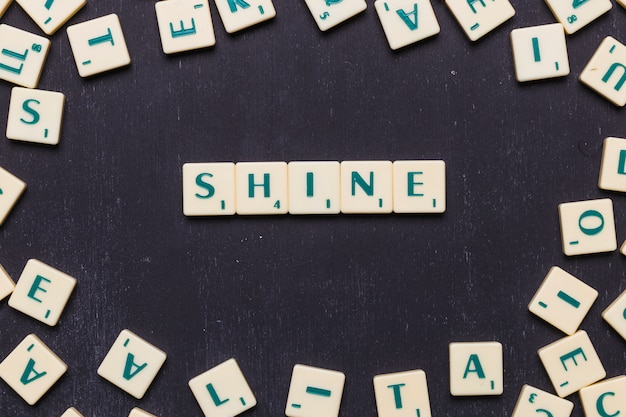 Free Photo word shine made from scrabble letters above black backdrop