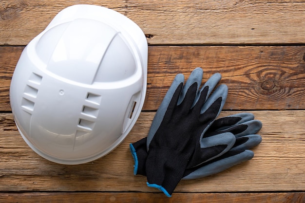 Work helmet and gloves on a wooden background top view