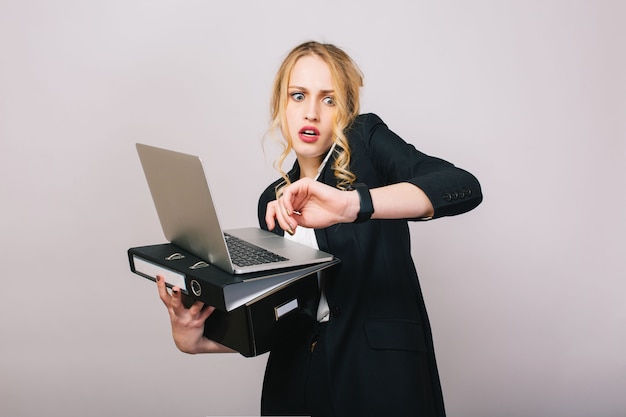 Work office busy time of blonde young woman in formal clothes with laptop, folder talking on phone. Astonished, working, profession, secretary, office worker, manager